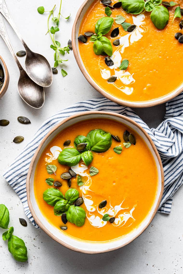 bowl of spicy butternut soup with basil and pumpkin seeds