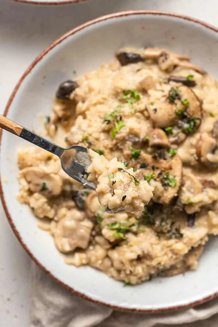 bite of vegan mushroom risotto over a bowl