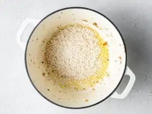 adding risotto rice to a pot