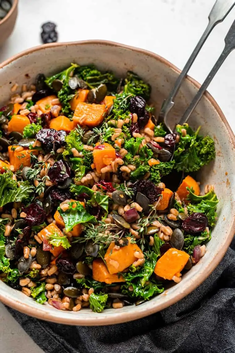 tossing farro salad with greens and potato