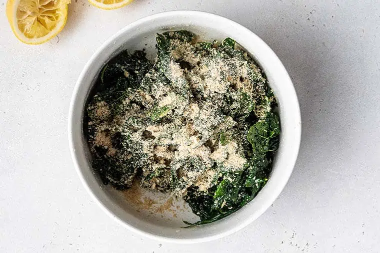 bowl of massaged kale with cheese on top