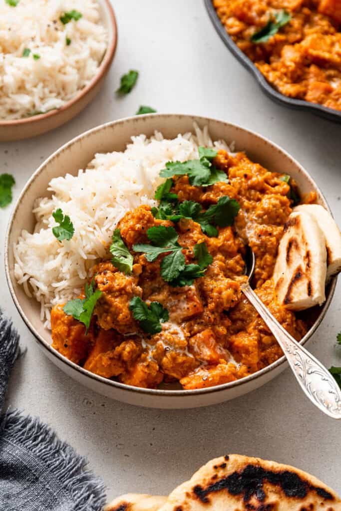 bowl of sweet potato curry with rice and naan