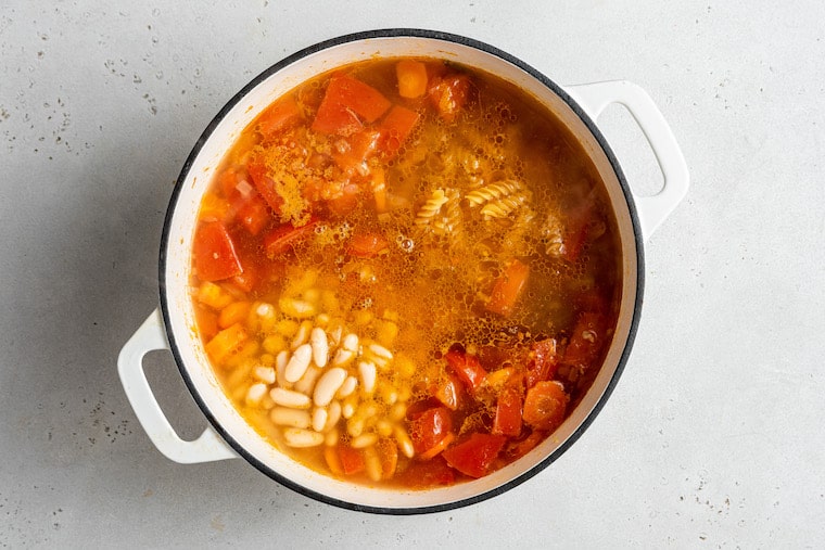 This hearty vegetable stew is packed with nutrients thanks to carrots, onion, and tomatoes, plus pasta and white beans for a satisfying meal. Overhead view of vegetable stew in pot