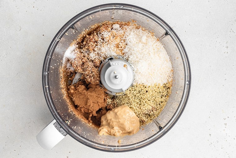 food processor with unmixed ingredients for energy bites