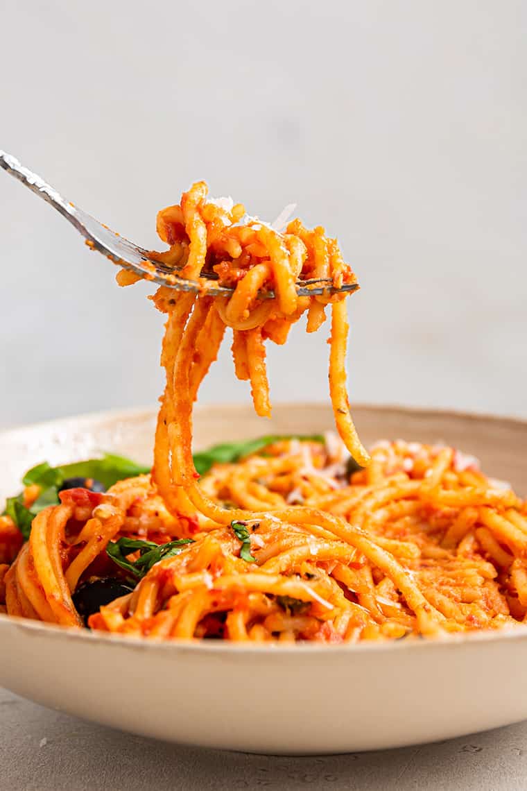bowl of pasta with toamto sauce on a fork