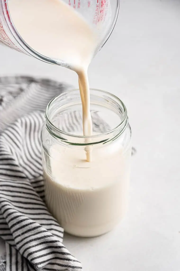 pouring vegan buttermilk into a glass jar