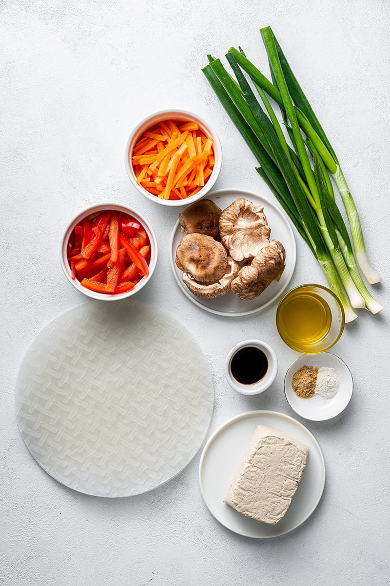 ingredients for dumplings with rice papper, carrots, peppers and scallions
