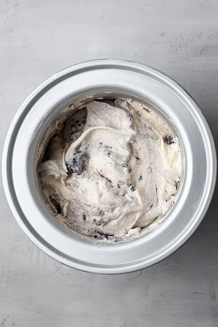 Overhead view of black raspberry ice cream in ice cream maker drum