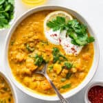Overhead view of detox turmeric lentil soup in bowl with spoon