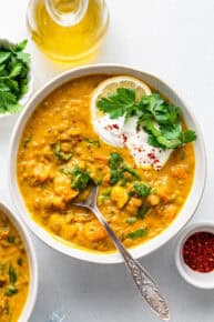 Overhead view of detox turmeric lentil soup in bowl with spoon