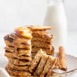 Stack of gluten-free pancakes topped with almond butter and apples