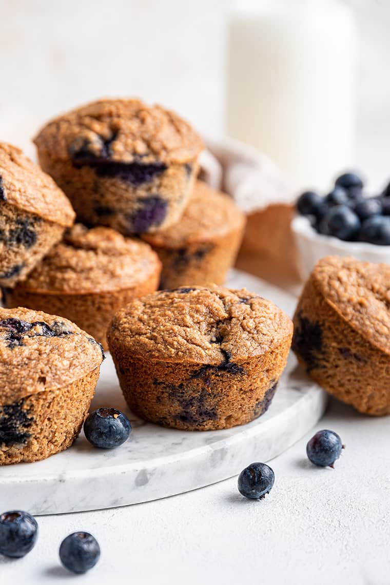 Round marble slab with healthy blueberry muffins stacked on top