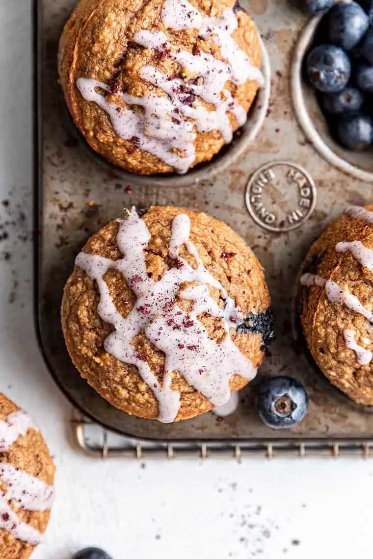 Overhead view of glazed blueberry muffins in muffin tin