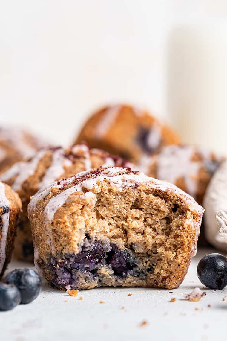 Healthy blueberry muffin with bite taken out to show light, fluffy texture inside
