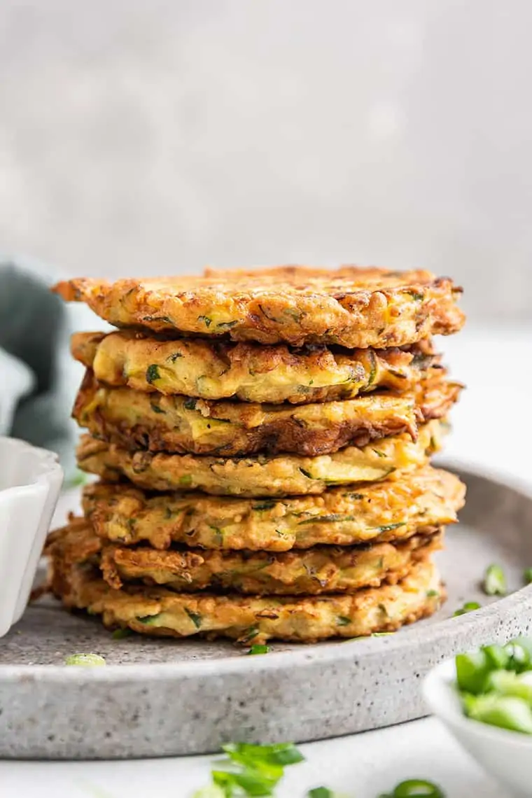 Stack of crispy zucchini fritters on plate