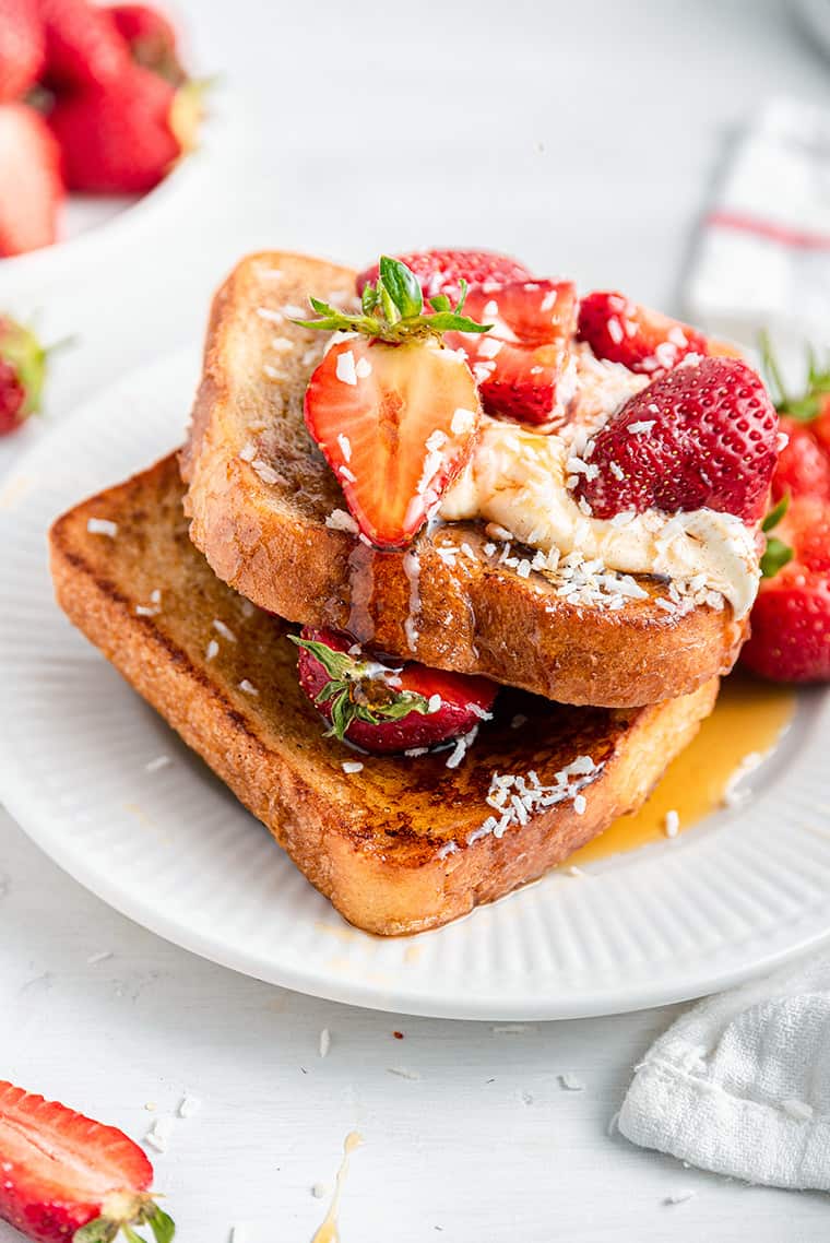 clsoe up on french toast with strawberries and maple syrup