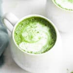 Two mugs of frothy matcha latte