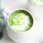 Two mugs of frothy matcha latte