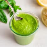 Jar of vegan green goddess salad dressing with spoon