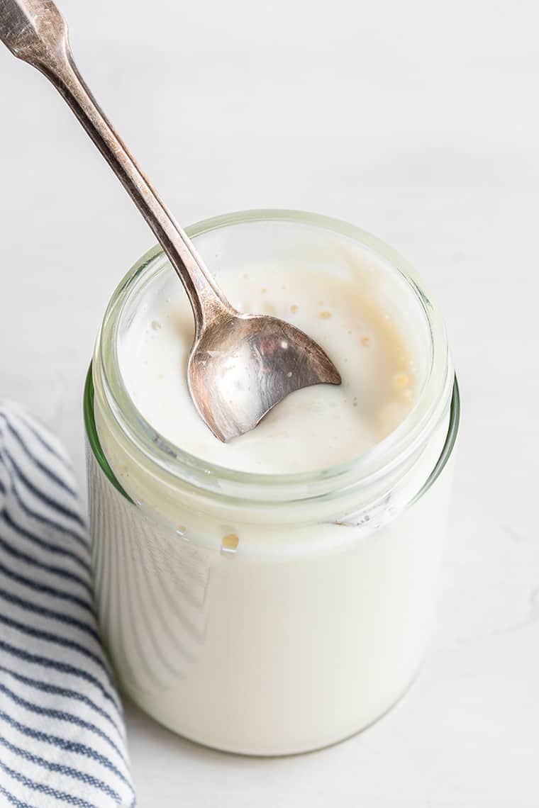 Jar of vegan sour cream with spoon