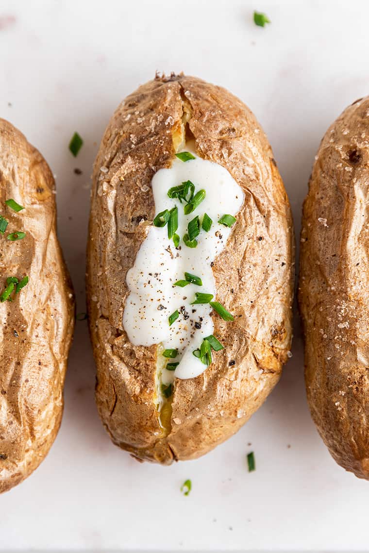 Baked potato topped with vegan sour cream and chives