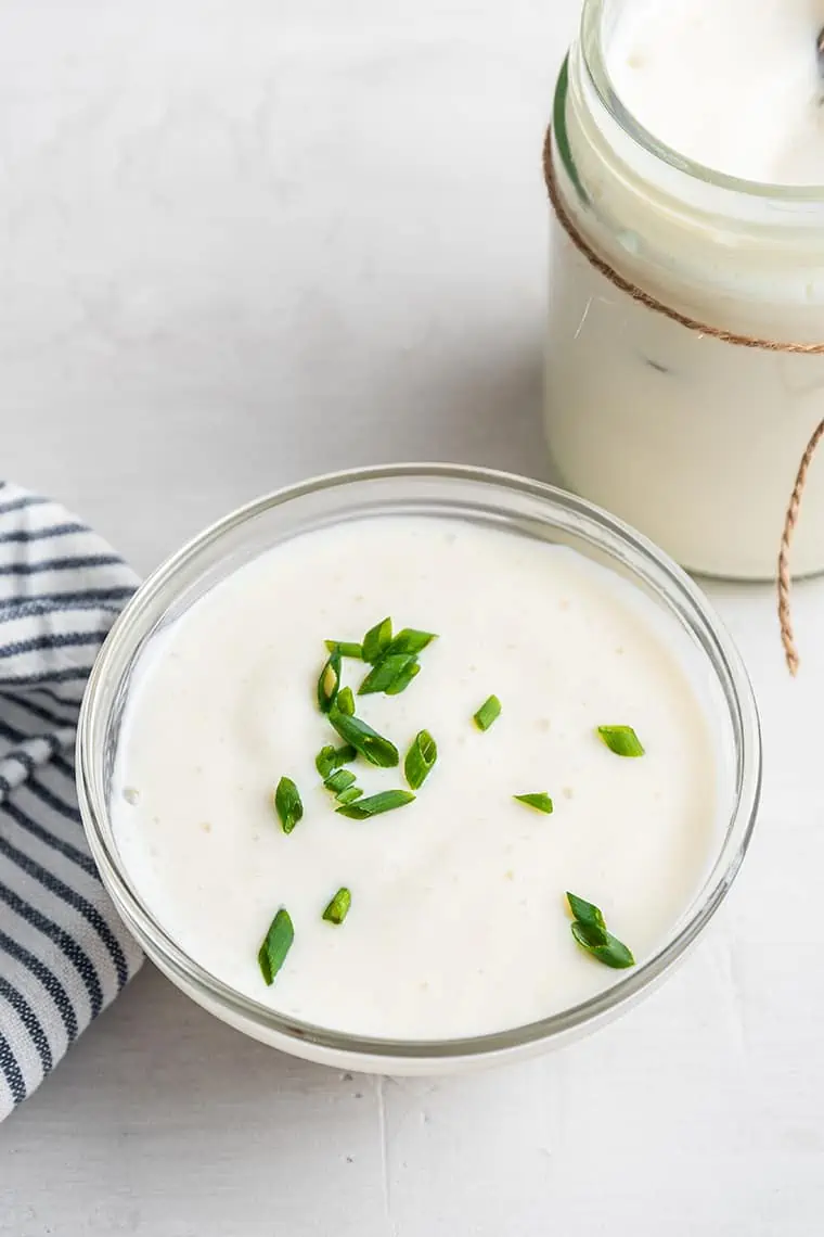 Bowl of vegan sour cream garnished with chives