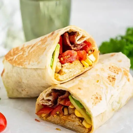A breakfast burrito cut it half, with one half propped on top of the other