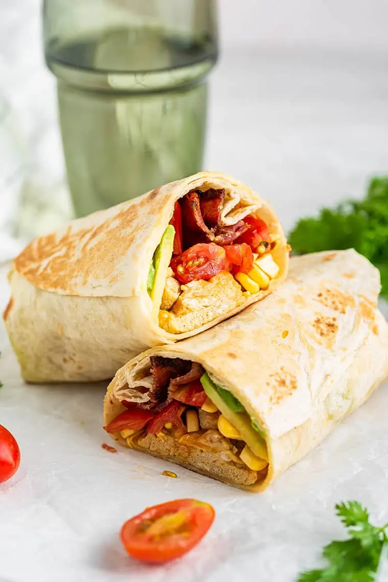 A breakfast burrito cut it half, with one half propped on top of the other