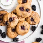 Overhead view of blackberry cookies on platter with glass of milk