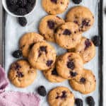 Overhead view of blackberry cookies on baking sheet with fresh berries