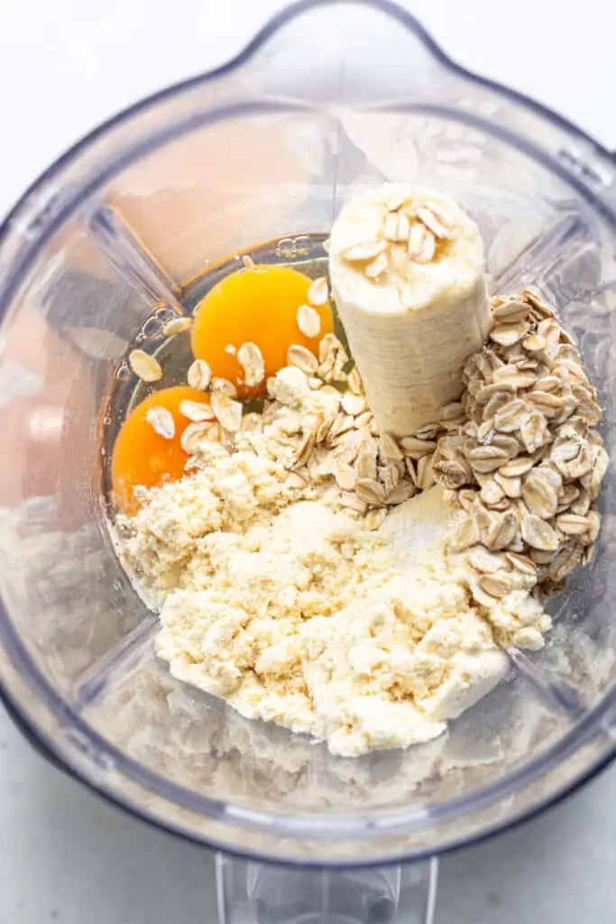 These protein pancakes are fluffy and flavorful, made with 6 ingredients in the blender. Gluten-free, dairy-free, and meal prep-friendly! The ingredients for protein pancakes combined inside a blender.