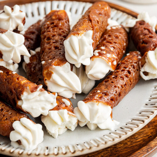 A plate full of finished filled brandy snaps
