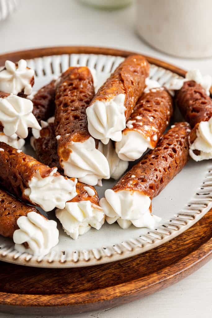 A plate full of finished filled brandy snaps