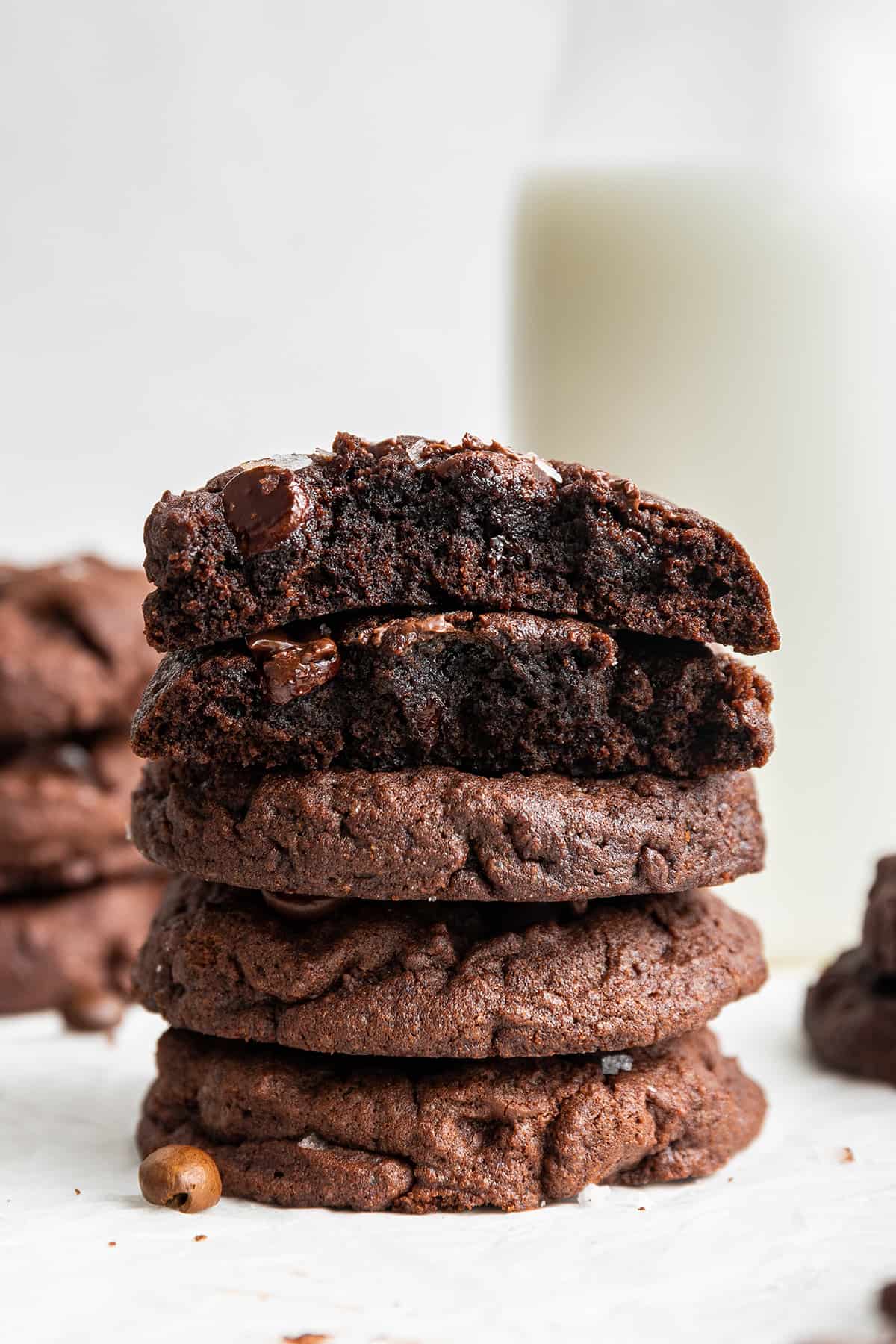 A stack of five espresso cookies on top of each other, with the top two torn in half