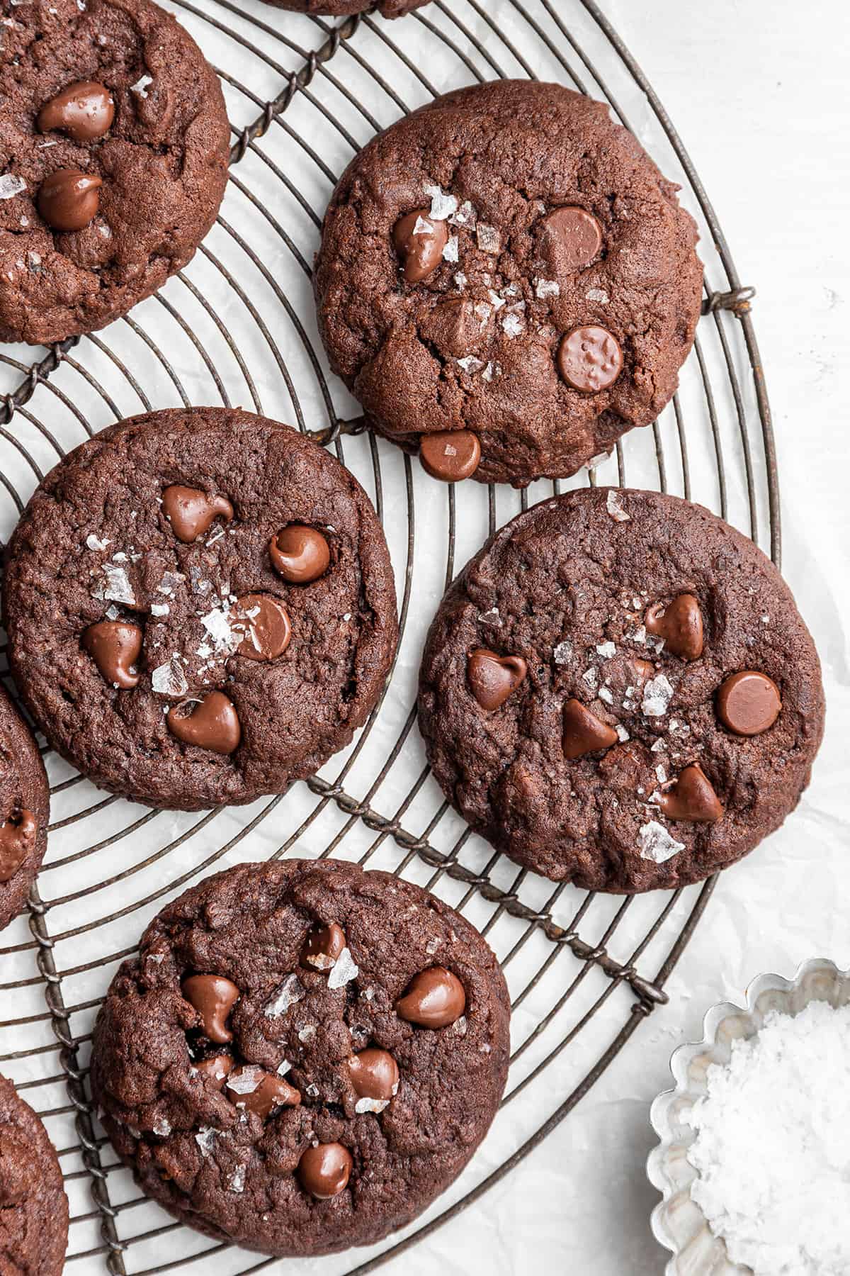 These dairy-free espresso cookies are chewy, packed with chocolate and espresso flavor, and topped with the perfect touch of finishing salt. Even better, it only takes about 20 minutes to make! Four espresso cookies, topped with flaky salt, on a circular wire rack