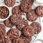 A circular wire rack filled with espresso cookies, next to a bowl of espresso beans