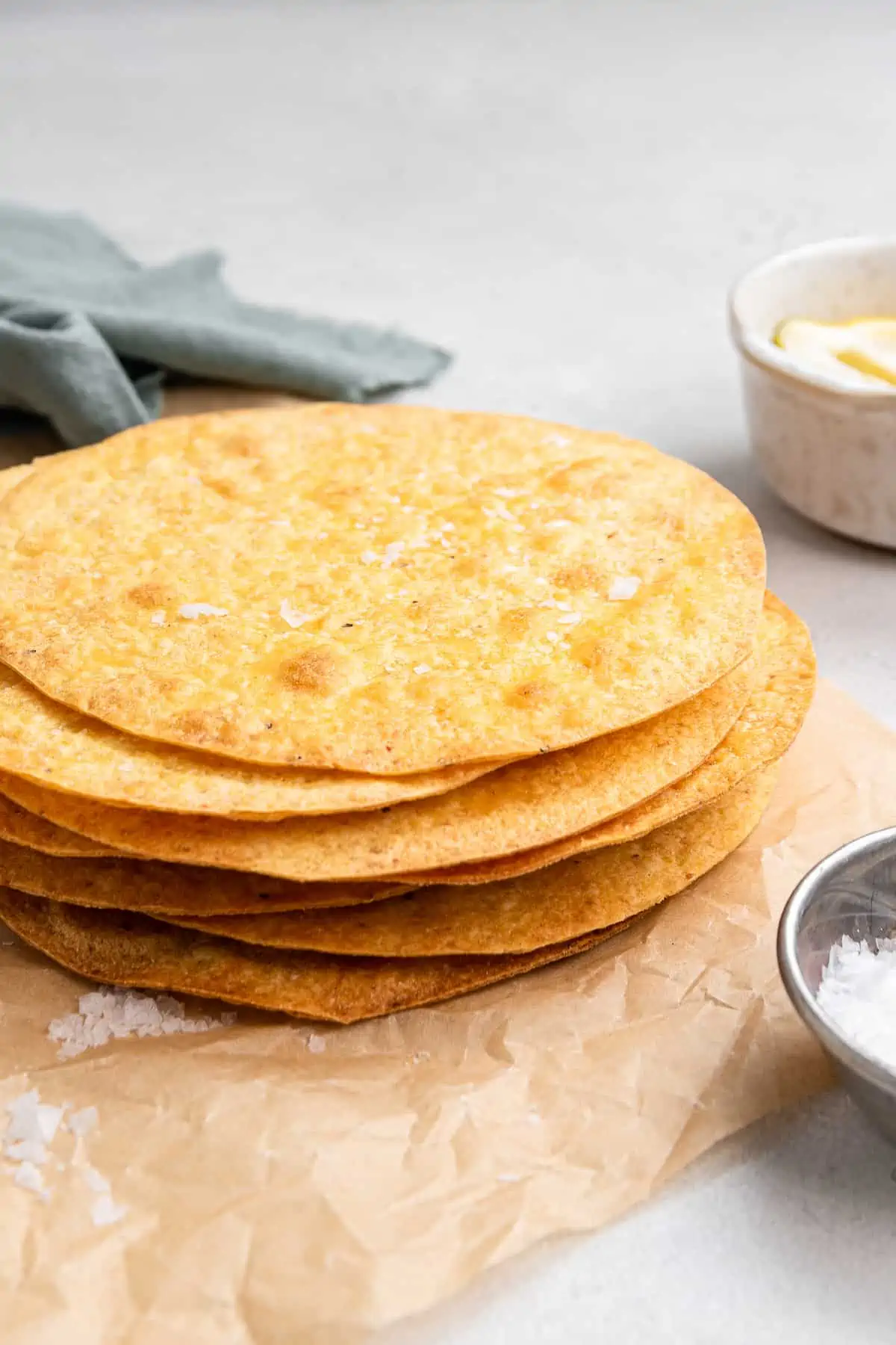 A stack of tostada shells on a sheet of parchment paper.