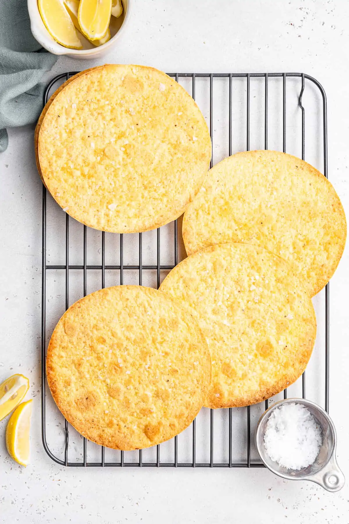 Learn to make homemade tostada shells that are golden-baked, crispy, and seasoned with flaky salt. No frying, and they're ready in 10 minutes! Tostada shells on a wire rack next to a small dish of flaky salt.