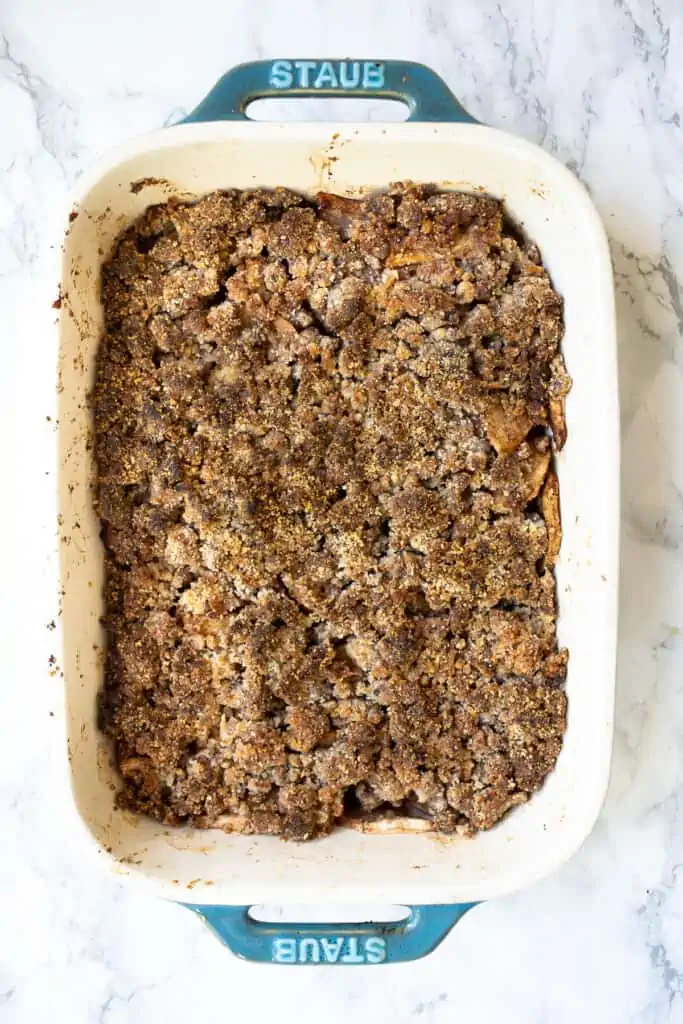 Baked gluten-free apple crisp in a white ceramic baking dish.