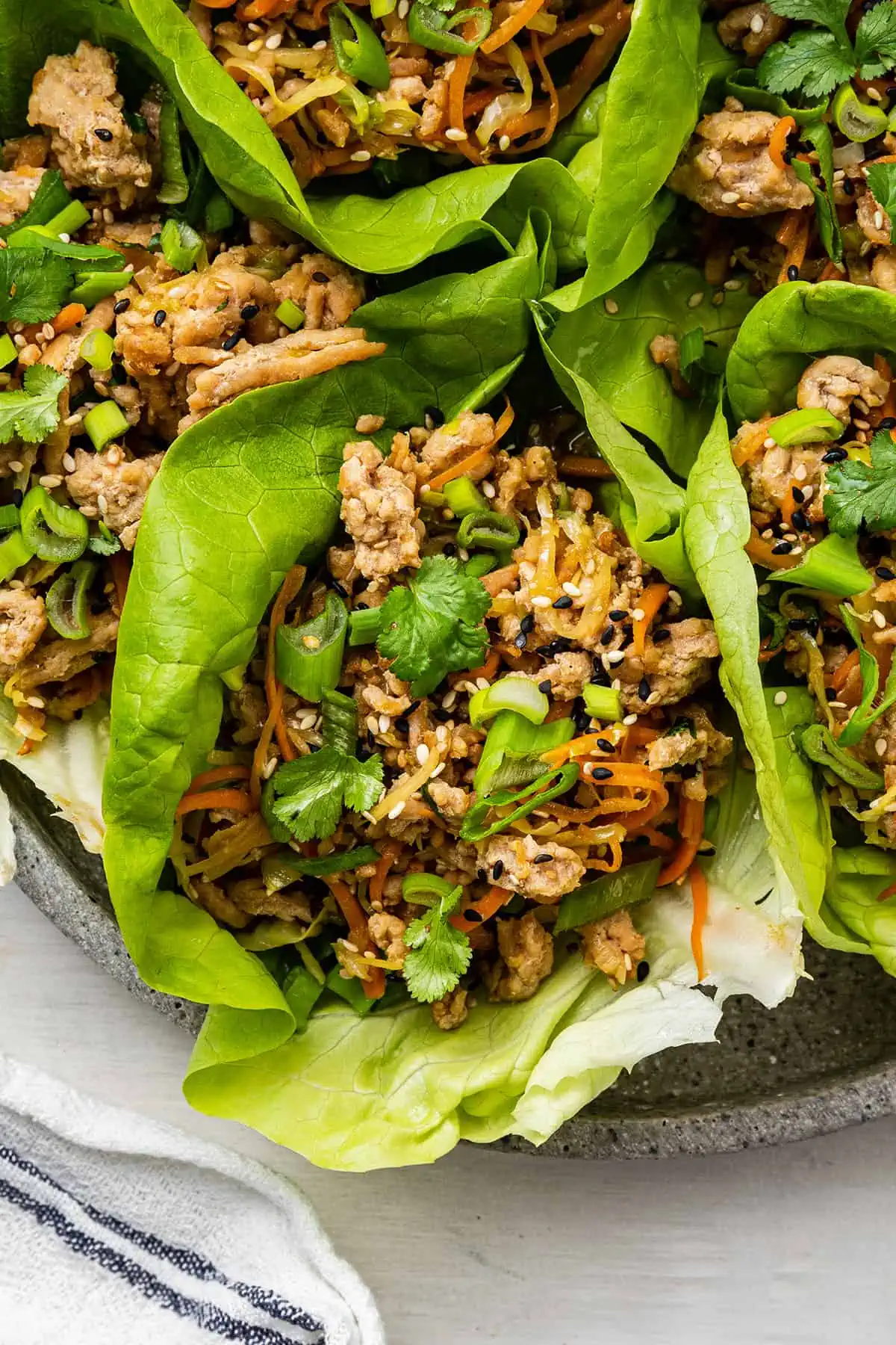 Close up of a chicken lettuce wrap on a tray of lettuce wraps