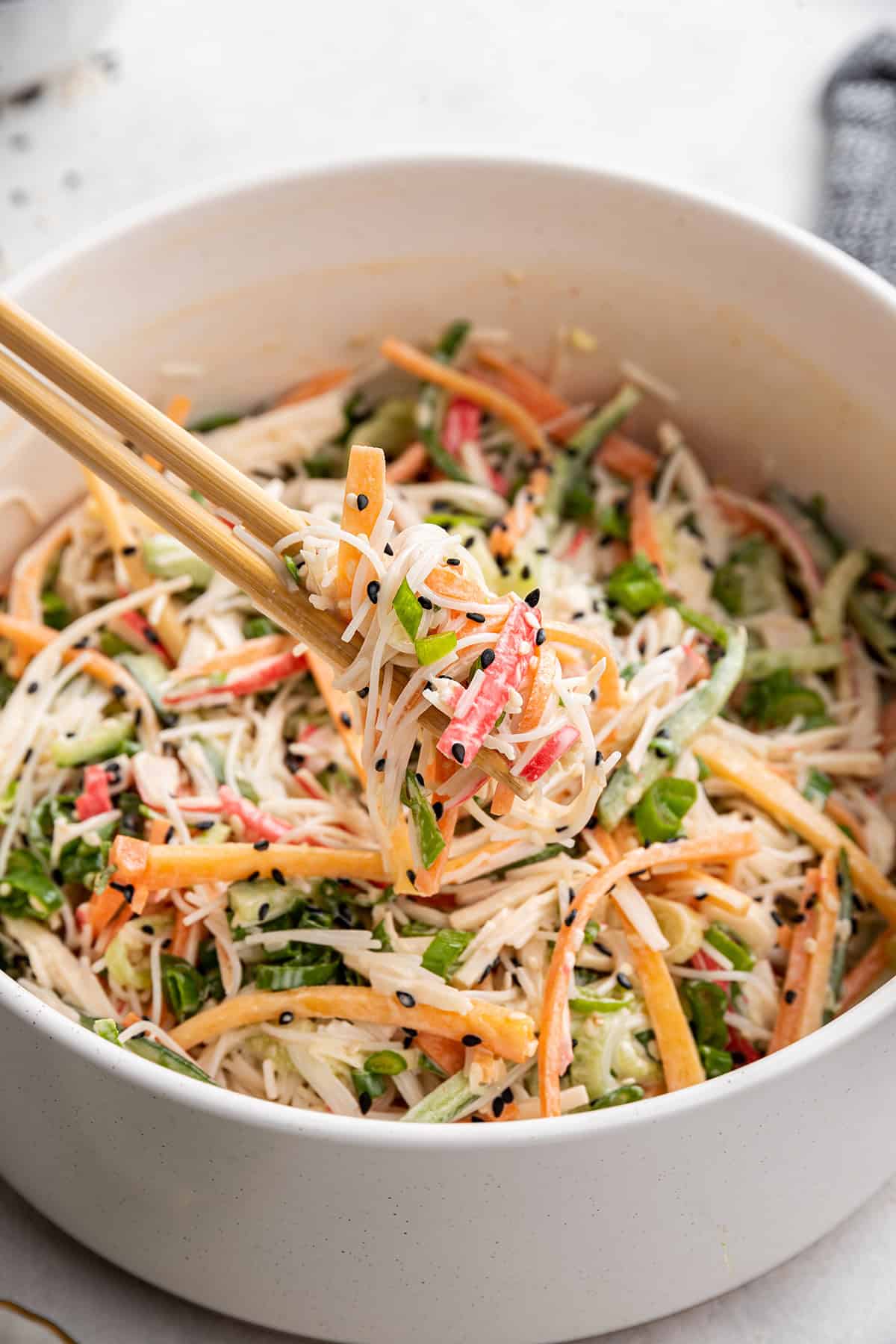 Close up of chopsticks lifting up a bite of kani salad
