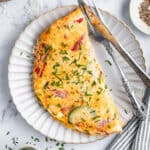 Overhead view of an egg white omelet on a plate with utensils.