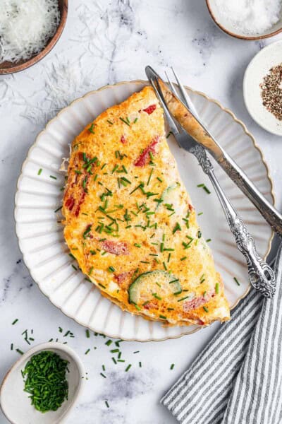 Overhead view of an egg white omelet on a plate with utensils.