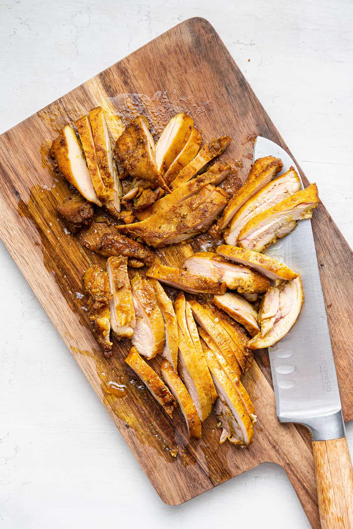 Overhead view of sliced chicken shawarma on cutting board with knife