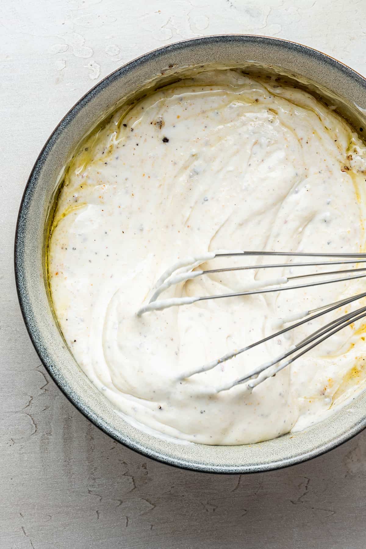 Overhead view of whisking yogurt dip in bowl