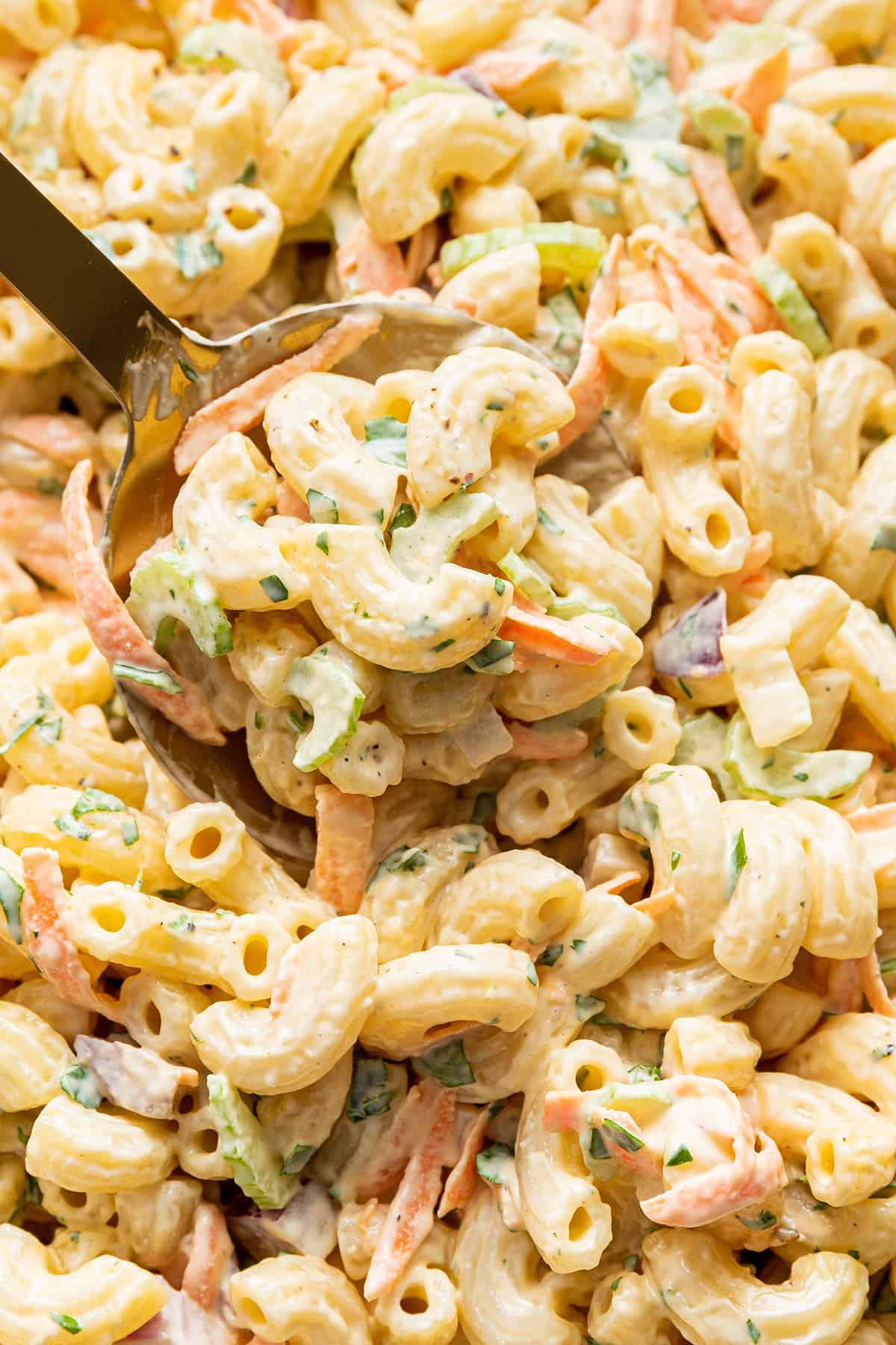Closeup view of serving spoon scooping Hawaiian macaroni salad