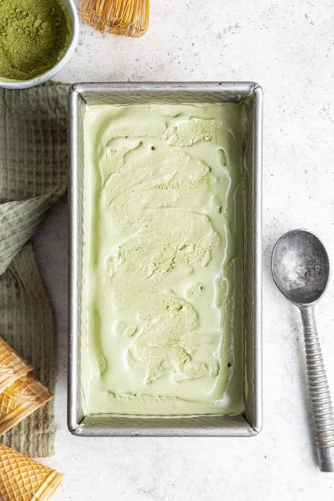 Overhead view of a loaf pan filled with not quite frozen matcha ice cream