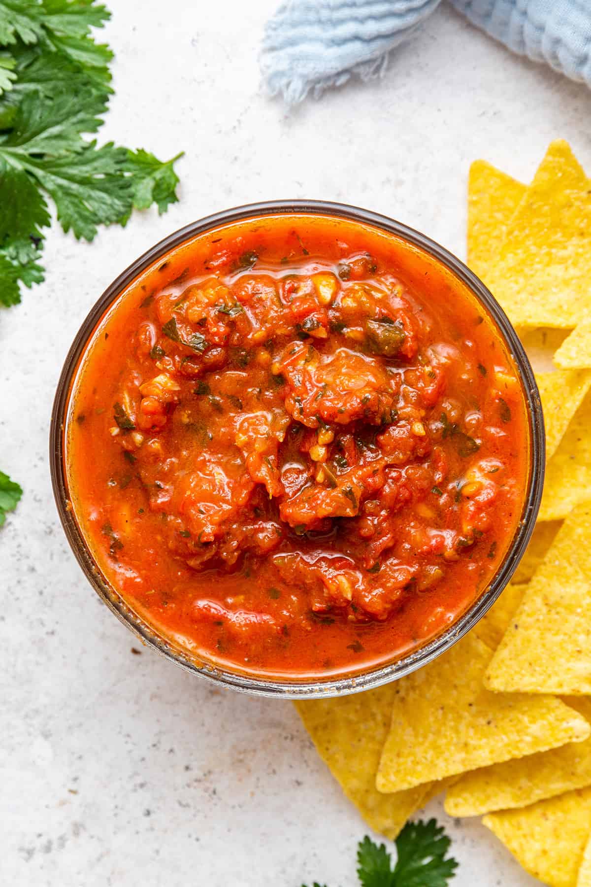 Salsa roja in glass bowl set next to tortilla chips