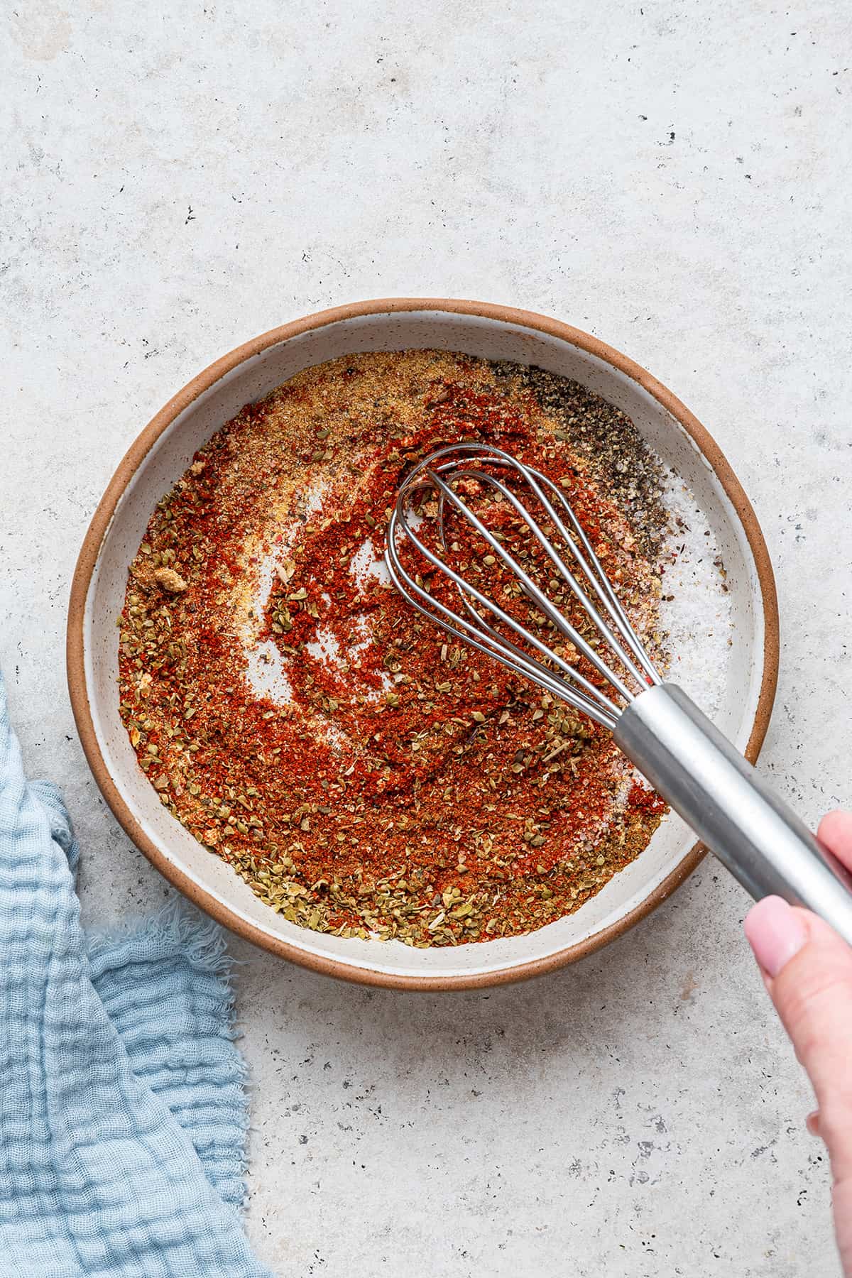 Whisking ingredients for blackened seasoning in a small bowl