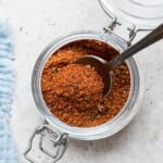 Spoon in open jar of blackened seasoning